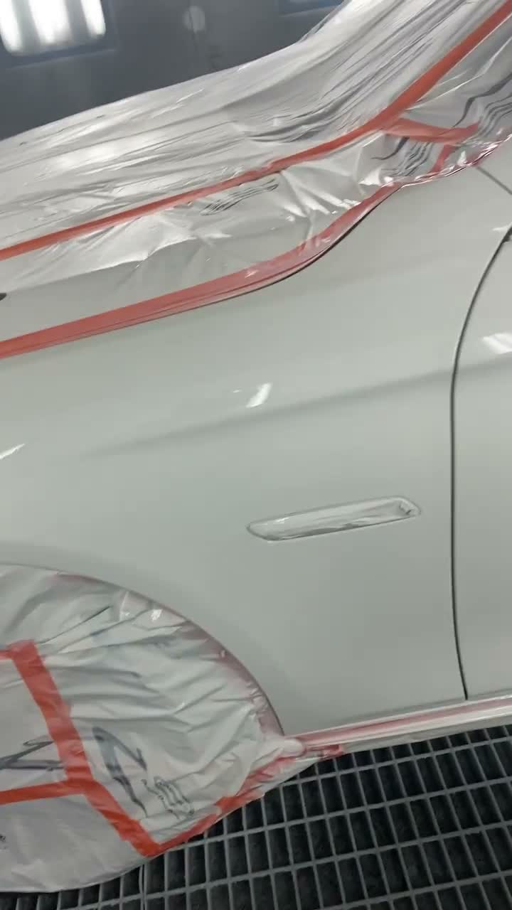 Vehicle in paint booth receiving professional refinishing